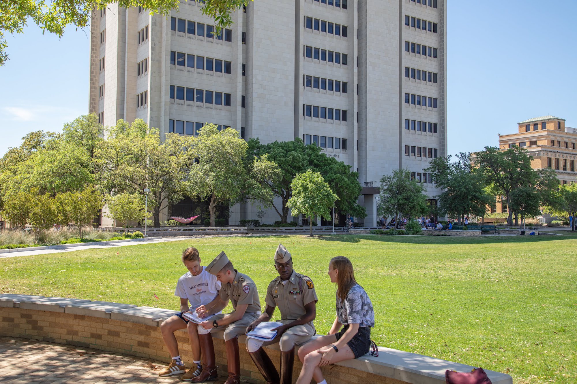 students studying on bench in front of O&M building
